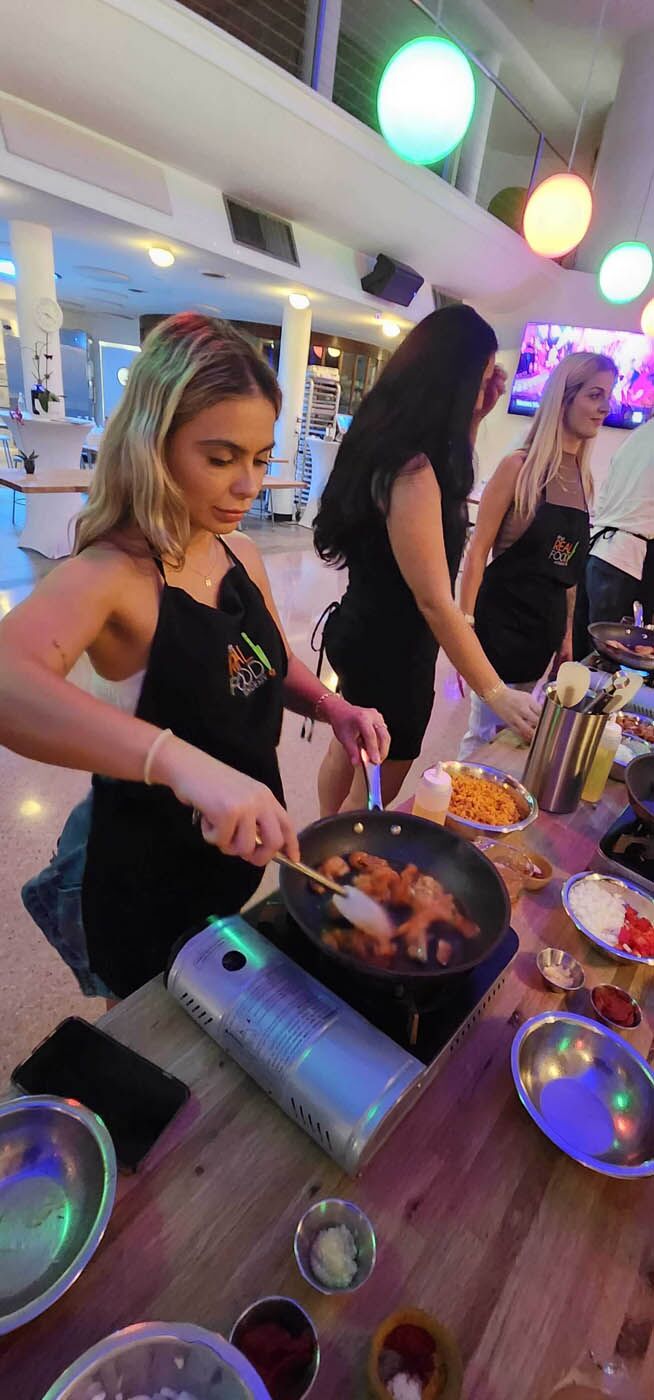 A women cooking in a pan at The Real Food Academy's party venue.