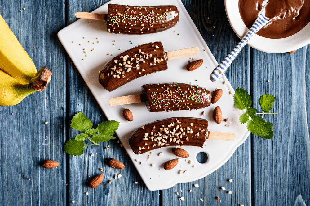 Bananas dipped in chocolate on a plate, try The Real Food Academy Miami recipe.