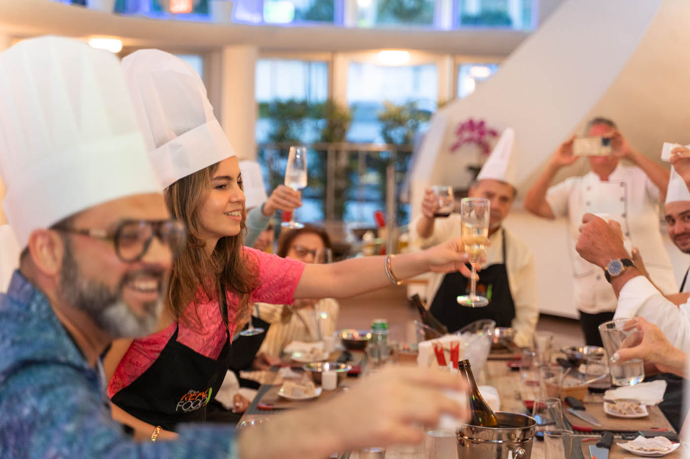 A group of adults cheering a drink at The Real Food Academy Miami.