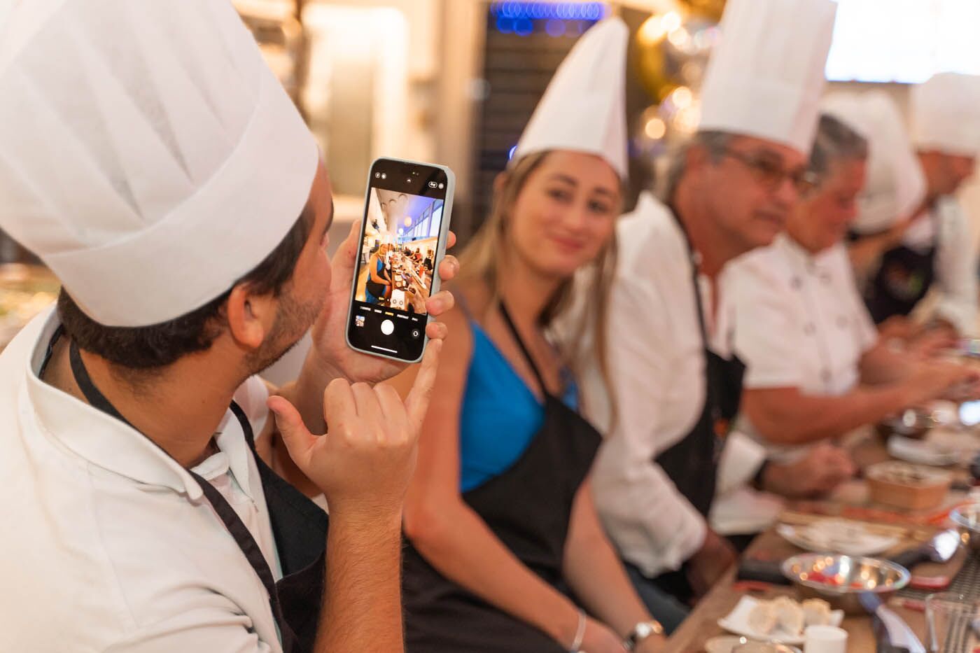 A man taking a picture of his corporate team at The Real Food Academy's team building cooking class.
