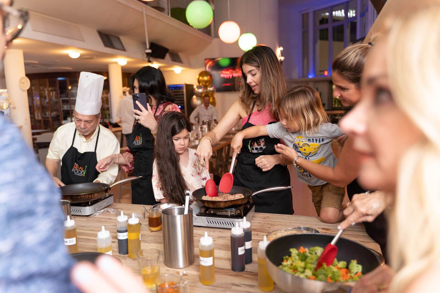 A mom with her kids participating at The Real Food Academy's chef class.