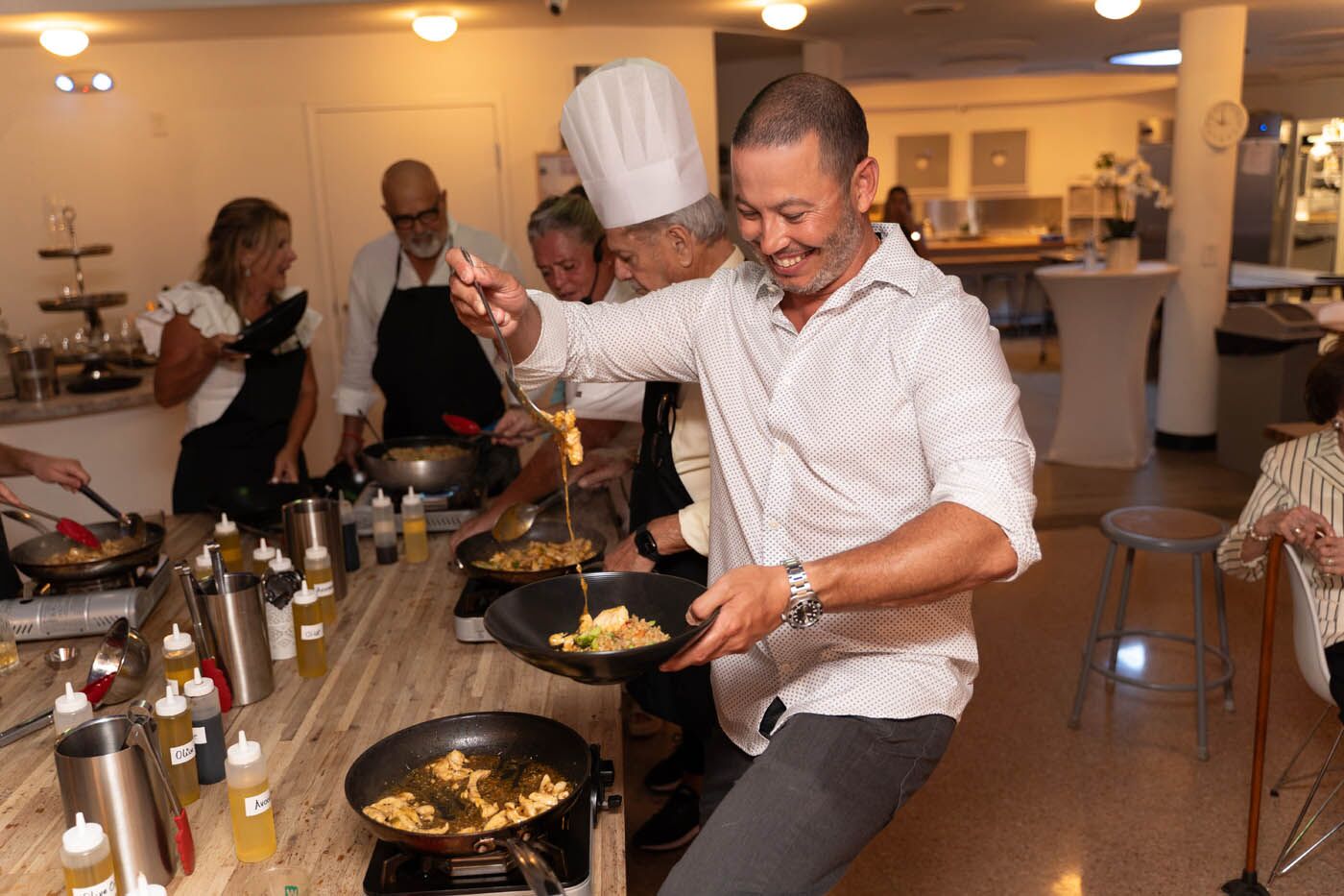 A man dancing with a fresh plate of food at The Real Food Academy's adult cooking class.