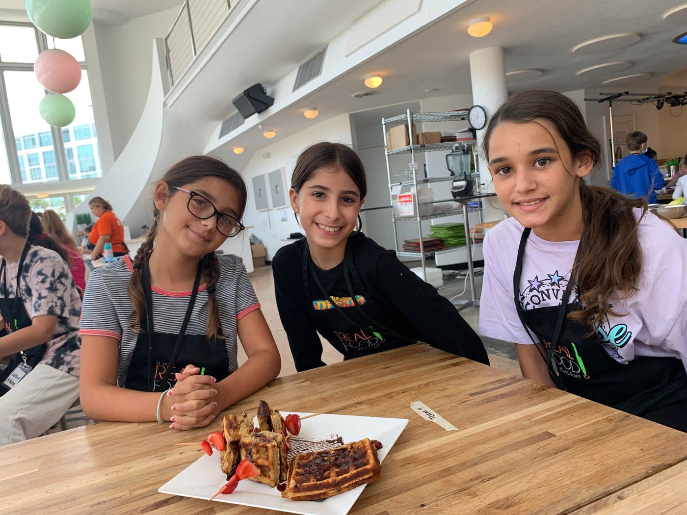 Kids cooking camp with The Real Food Academy - three girls showing off their creation!
