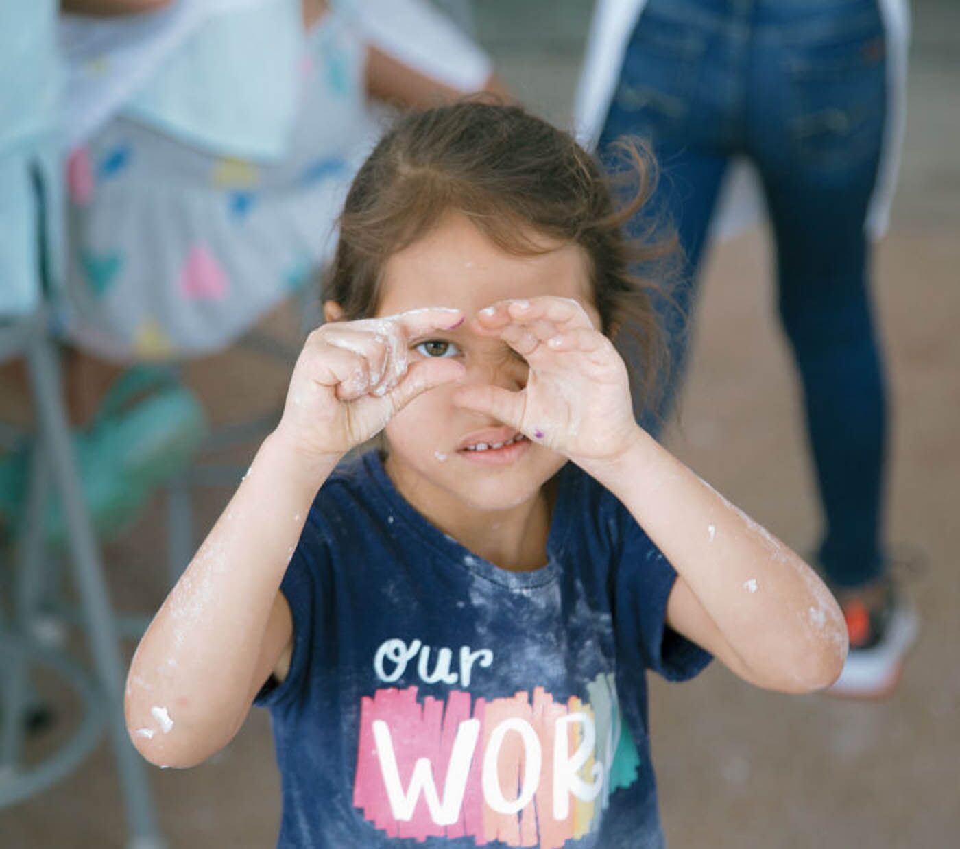 A young girl covered in flower, but having a great time at The Real Food Academy's kids cooking camp.