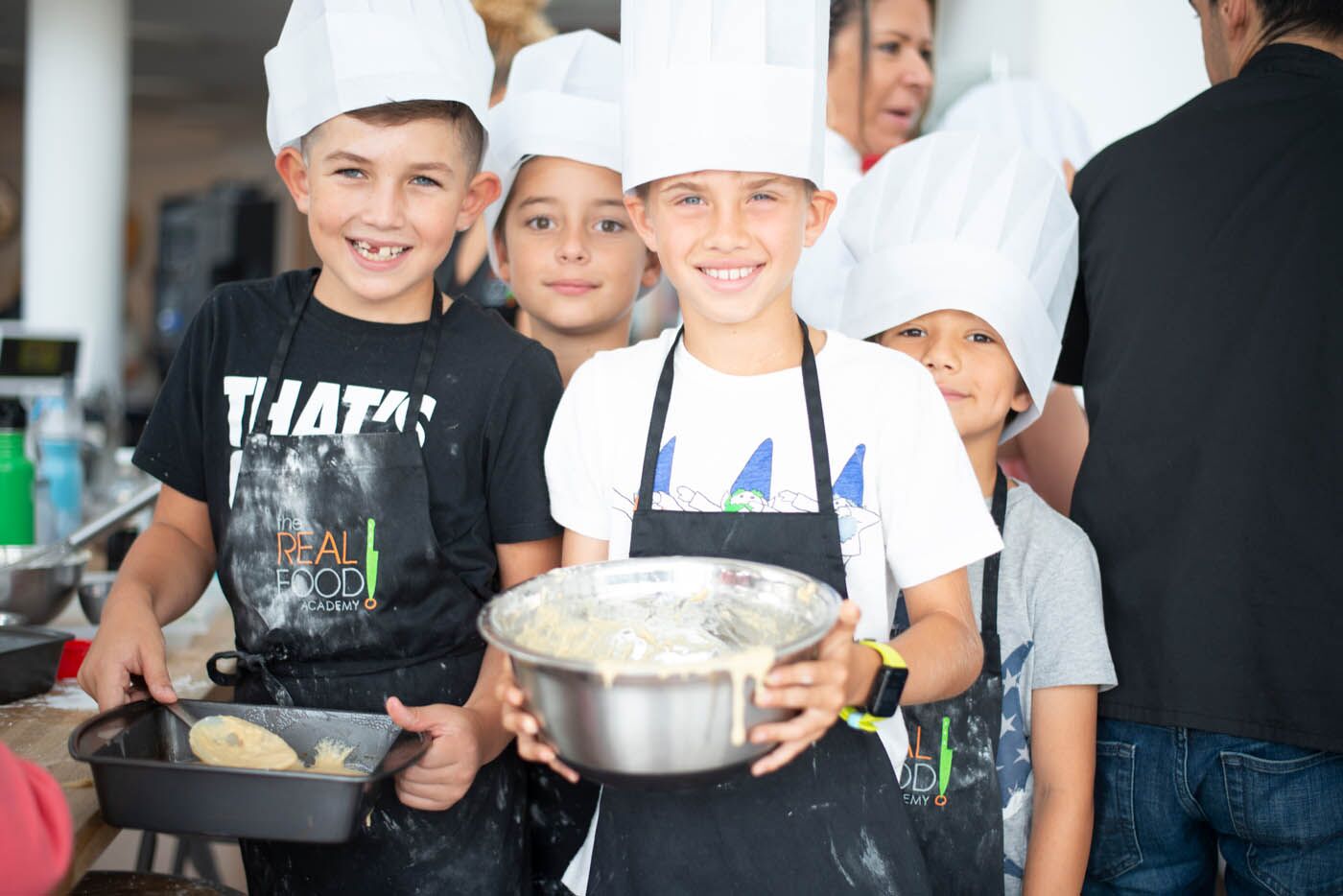 A young man holding a bowl at The Real Food Academy's cooking summer camp.