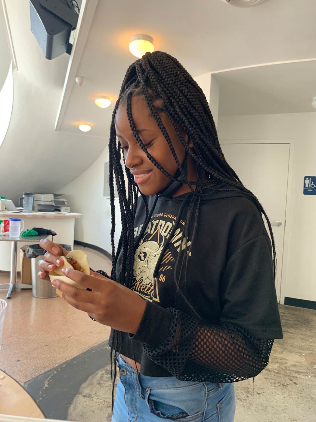 A young girl enjoying a fresh taco at The Real Food Academy cooking classes for teens.