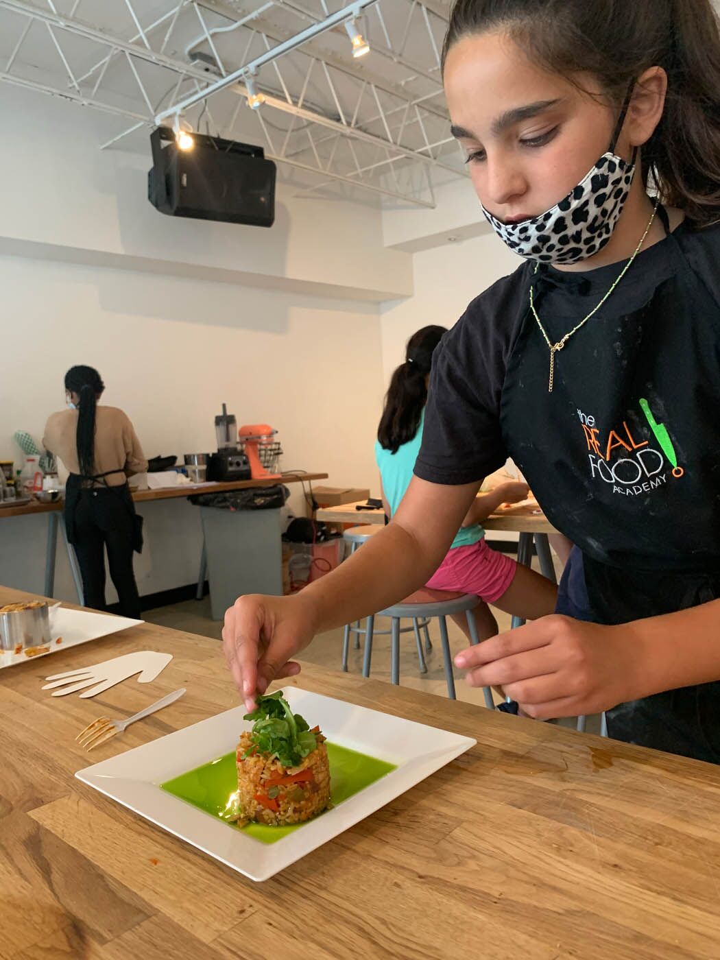 A young teen creating a delicious meal - The Real Food Academy offers summer programs for teens so they can explore their creativity!