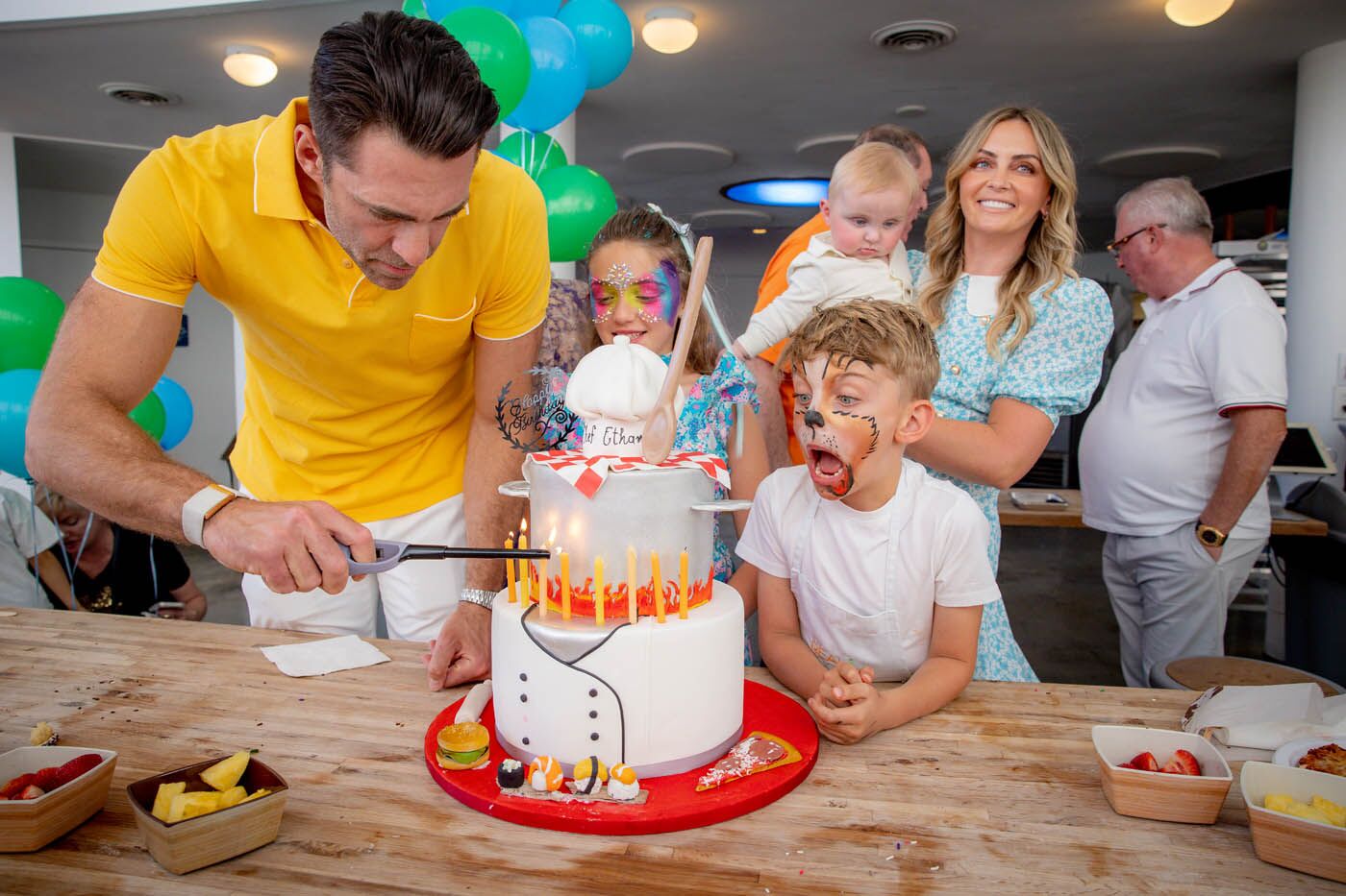 A parent cutting a cake at The Real Food Academy party.