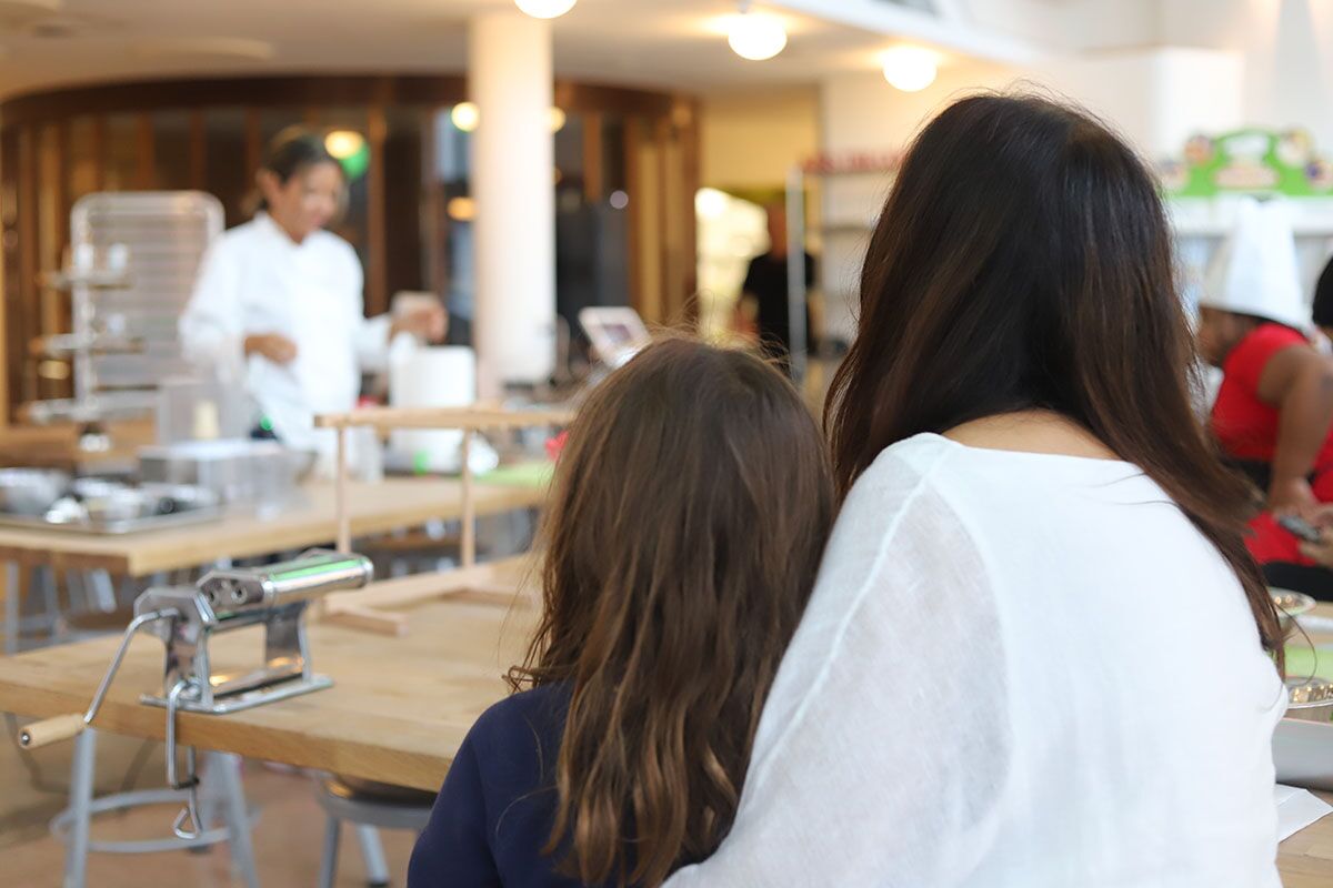 The back of a mom and daughters head watching chef marie teach our mommy and me classes.