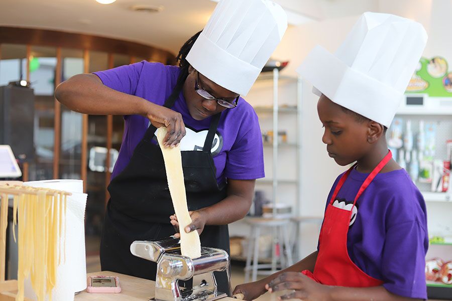 A mom and son rolling fresh pasta at The Real Food Academy.